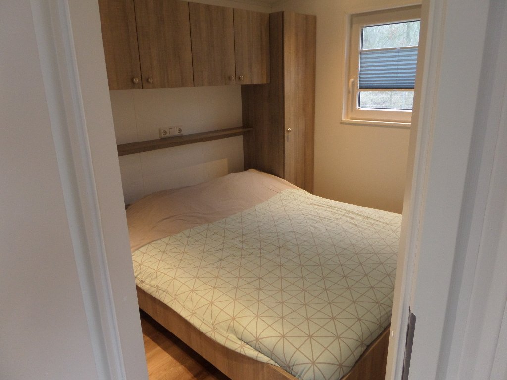 Slaapkamer met tweepersoonsbed en kastruimte